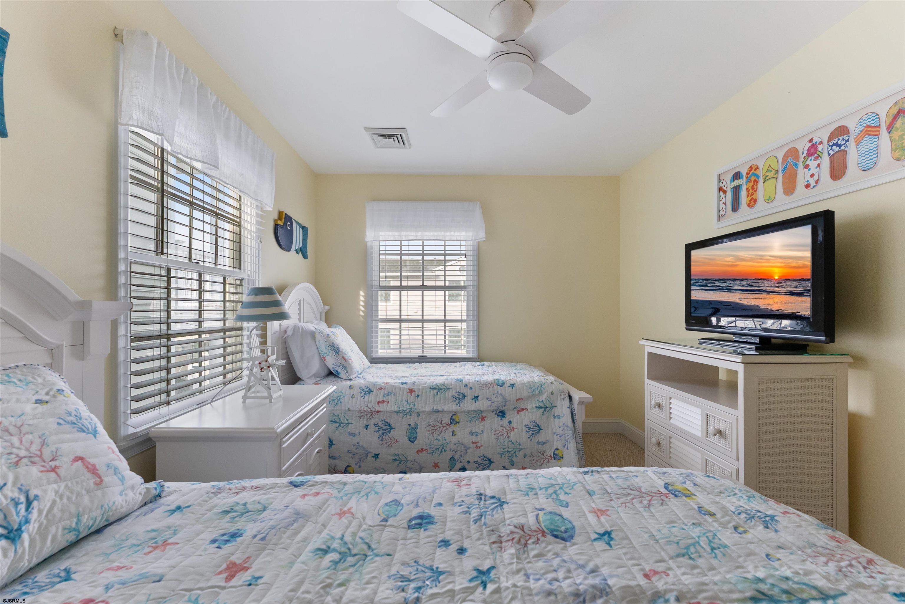 4930 Asbury Avenue, Unit 2 Ocean City, NJ 08226 - Photo 18 of 25 a bedroom with a bed and a flat screen tv