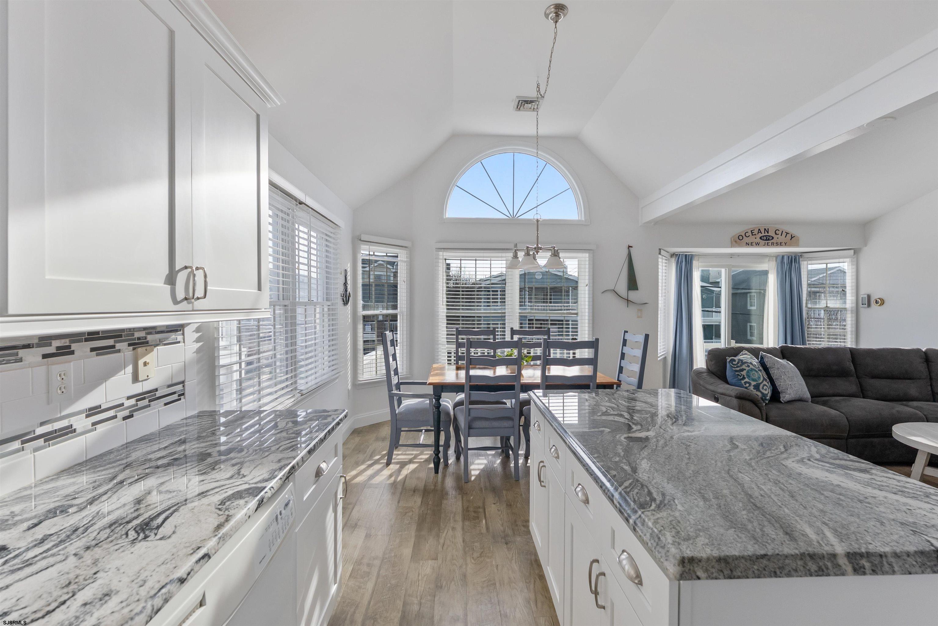 4930 Asbury Avenue, Unit 2 Ocean City, NJ 08226 - Photo 9 of 25 a living room with granite countertop kitchen island stainless steel appliances furniture a chandelier a large window and a sink
