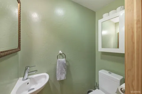 a bathroom with a sink and mirror with toilet