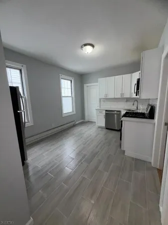 a view of kitchen with sink microwave and cabinets
