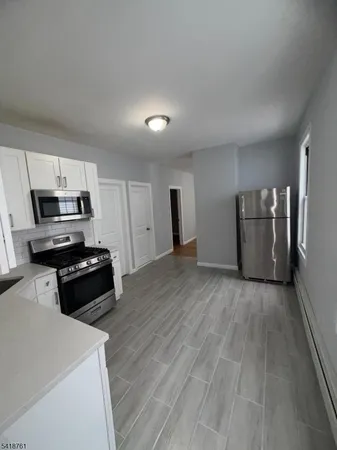 a kitchen with a refrigerator and a stove top oven