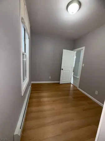 a view of room with window and wooden floor