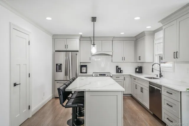 a kitchen with a sink a stove a refrigerator and white cabinets