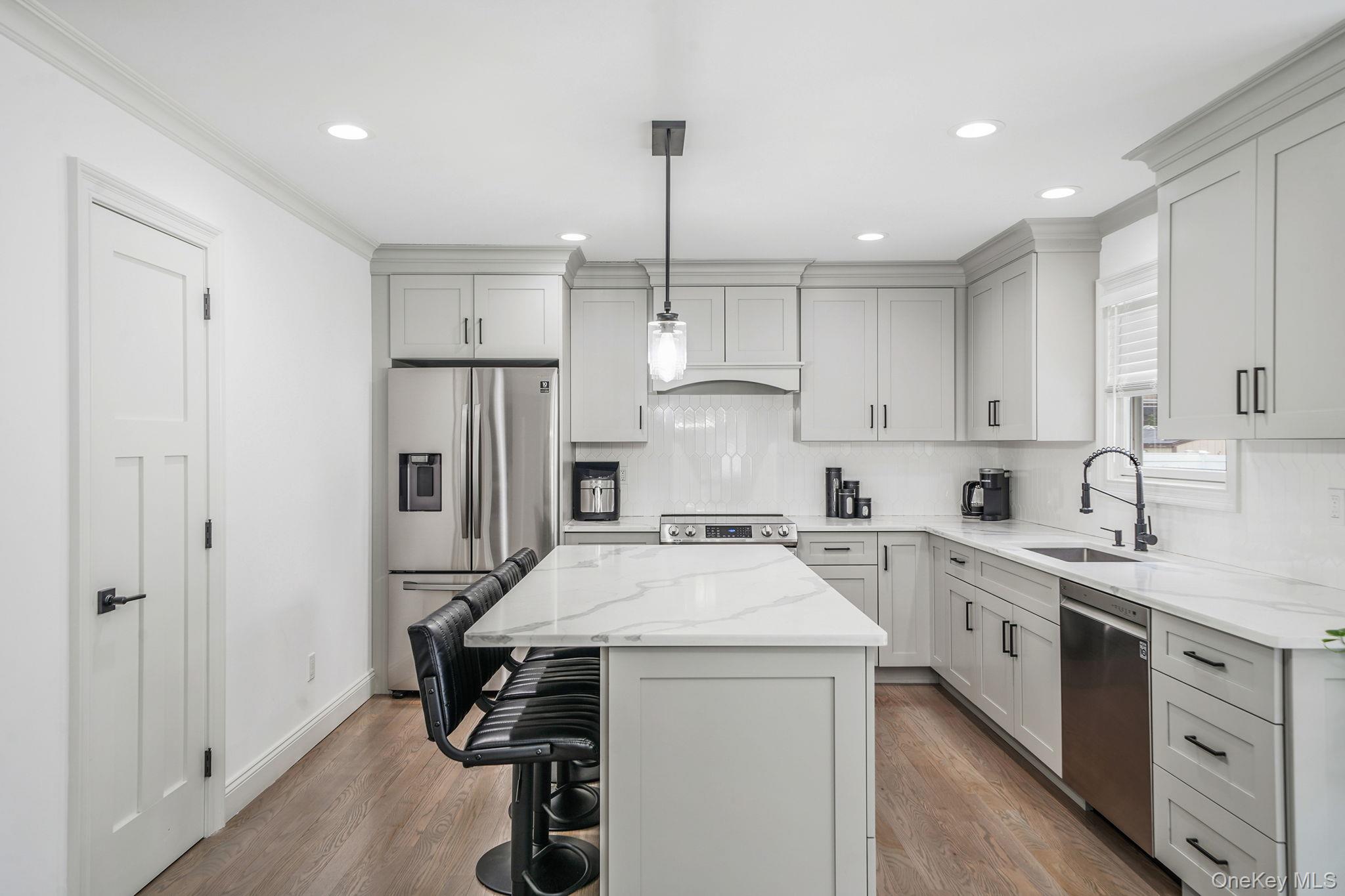 122 4th Street St. James, NY 11780 - Photo 11 of 36 a kitchen with a sink a stove a refrigerator and white cabinets