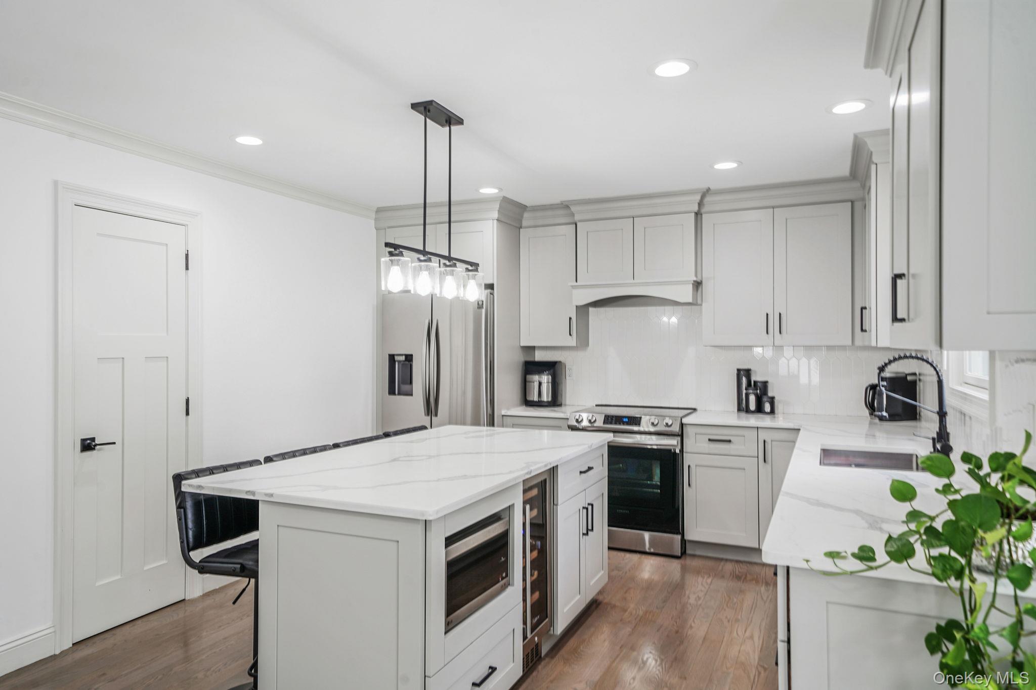 122 4th Street St. James, NY 11780 - Photo 10 of 36 a kitchen with stainless steel appliances granite countertop a sink stove and refrigerator