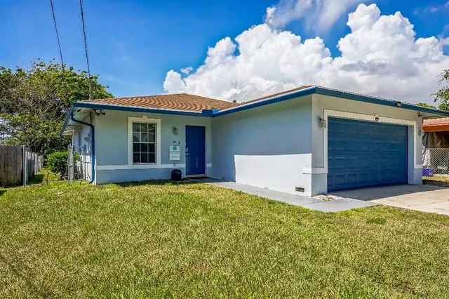 a view of a house with a yard and a garage
