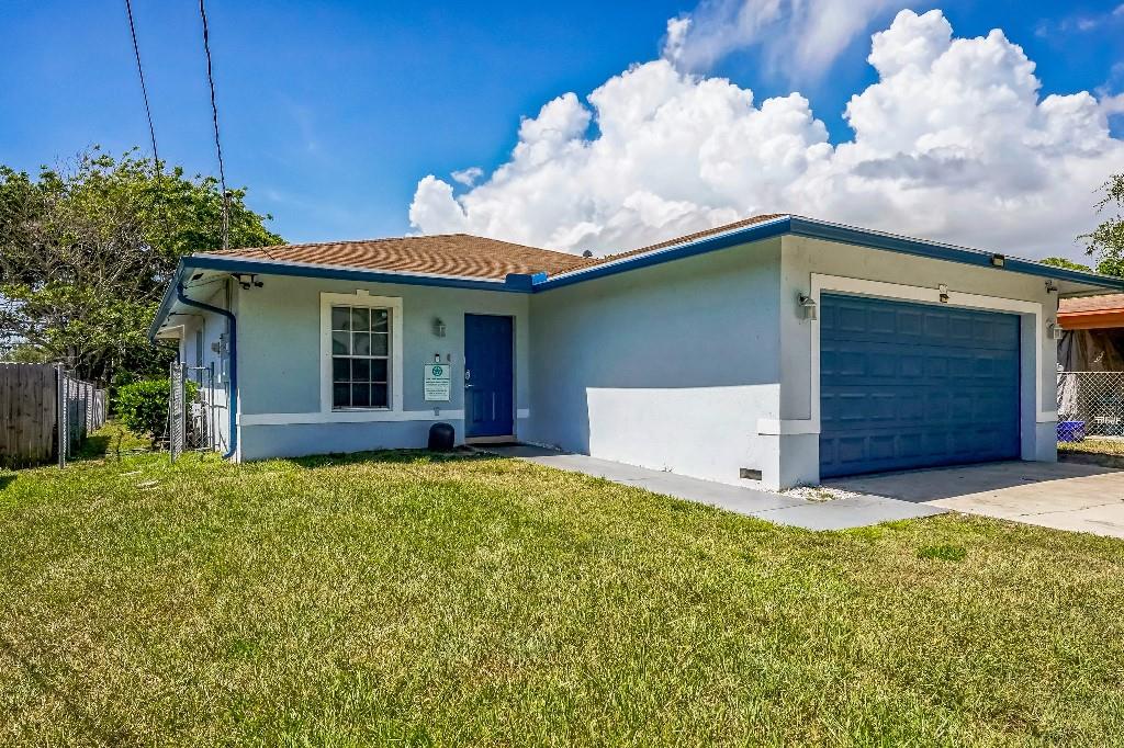 a view of a house with a yard and a garage