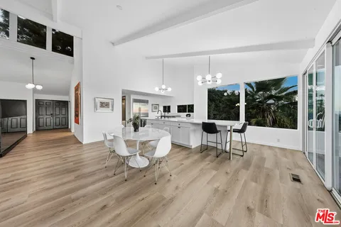 a large white kitchen with lots of counter space a sink and stainless steel appliances