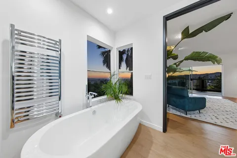 a bathroom with a tub shower and mirror