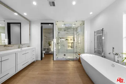 a bedroom with a large bed and a view of living room