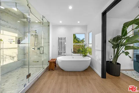 a bedroom with a bed and large mirror with a rug