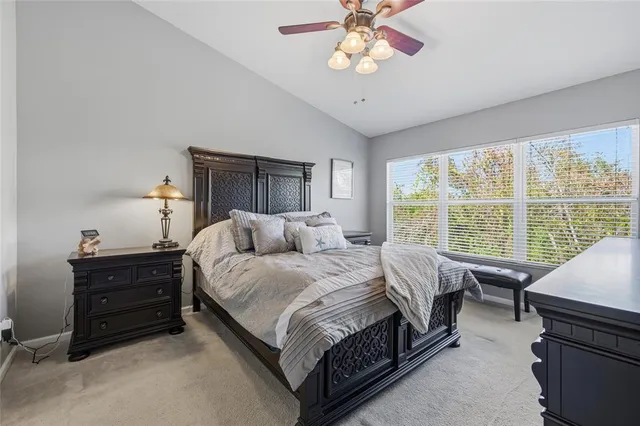 a spacious bedroom with a bed and a chandelier