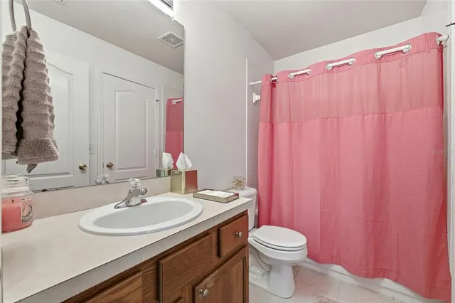 a bathroom with a sink a toilet a mirror and shower curtain