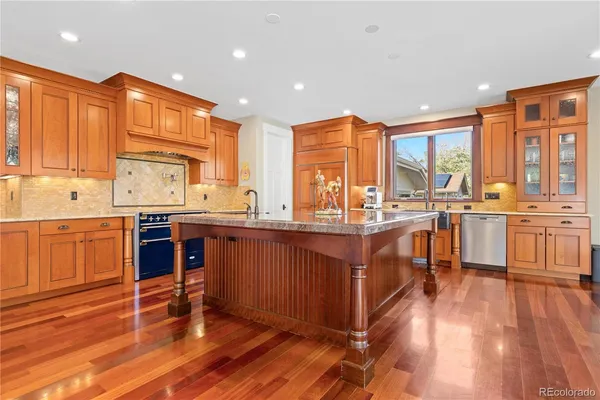 a living room with couches and kitchen view with wooden floor