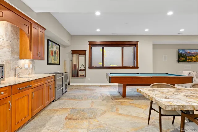 a living room with furniture a table and kitchen view