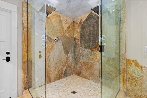 a spacious bathroom with a granite countertop sink a mirror and a shower