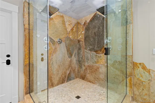 a spacious bathroom with a granite countertop sink a mirror and a shower
