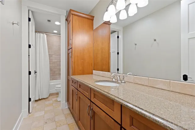 a spacious bedroom with a bed and painting on the wall