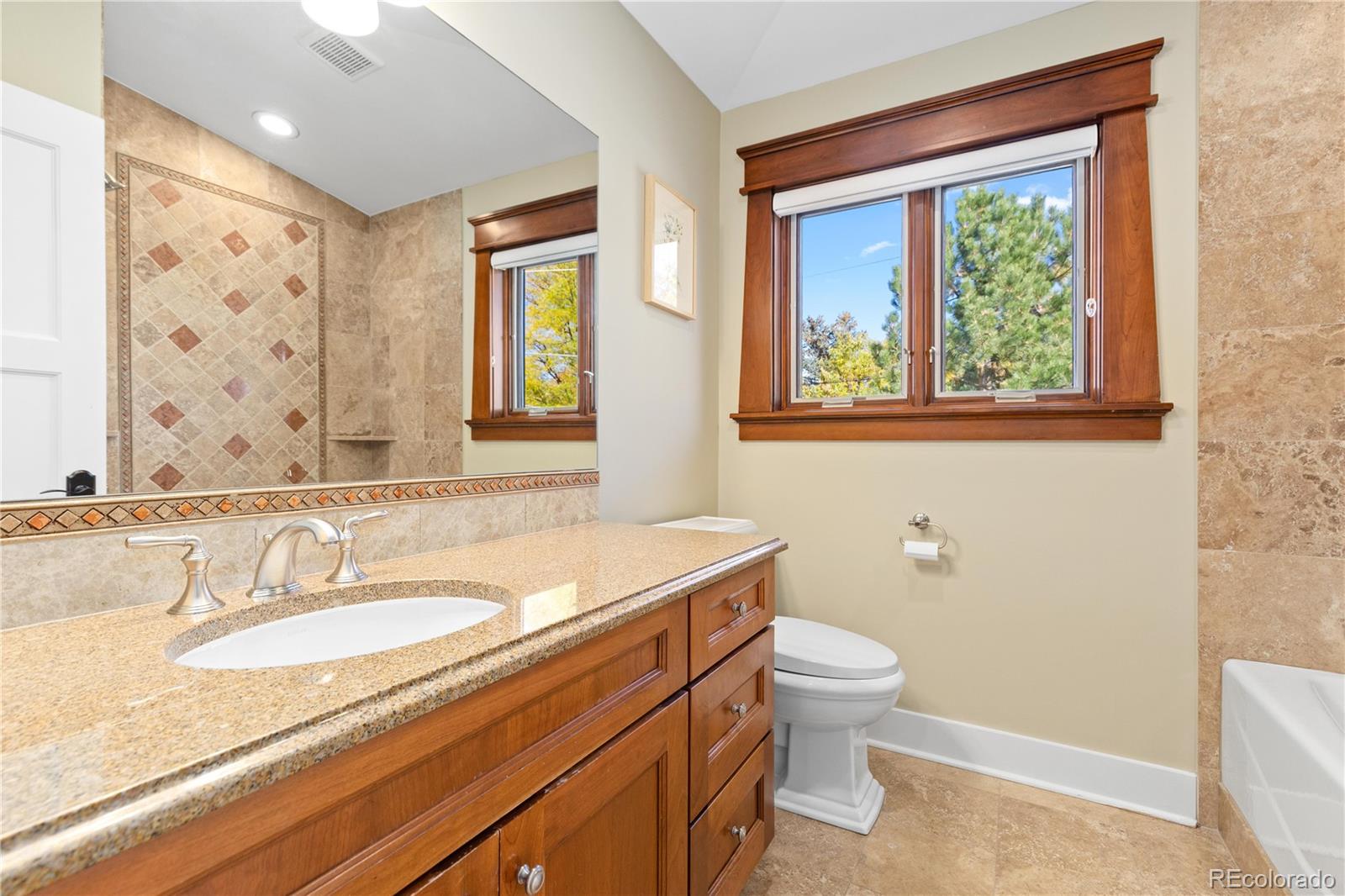 800 Grant Place Boulder, CO 80302 - Photo 34 of 50 a bathroom with a granite countertop sink a toilet and a large mirror