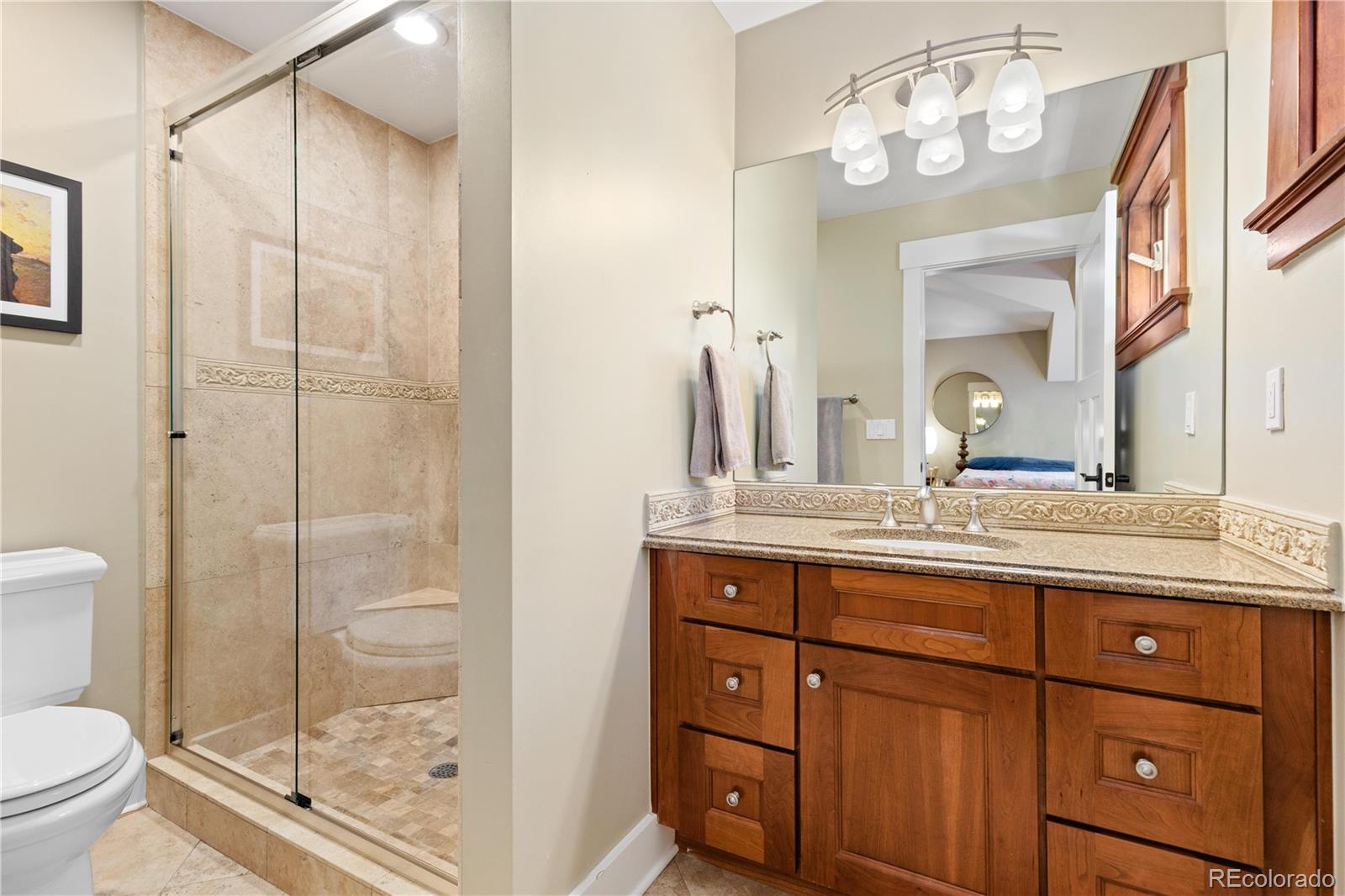 800 Grant Place Boulder, CO 80302 - Photo 36 of 50 a bathroom with a granite countertop sink a toilet and a mirror