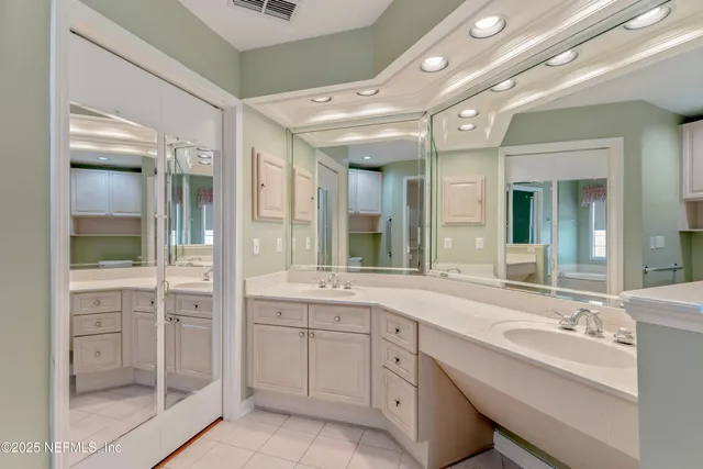 a spacious bathroom with a shower sink and mirror