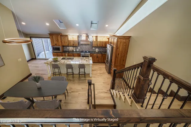 a view of kitchen with kitchen island stainless steel appliances refrigerator stove microwave and cabinets