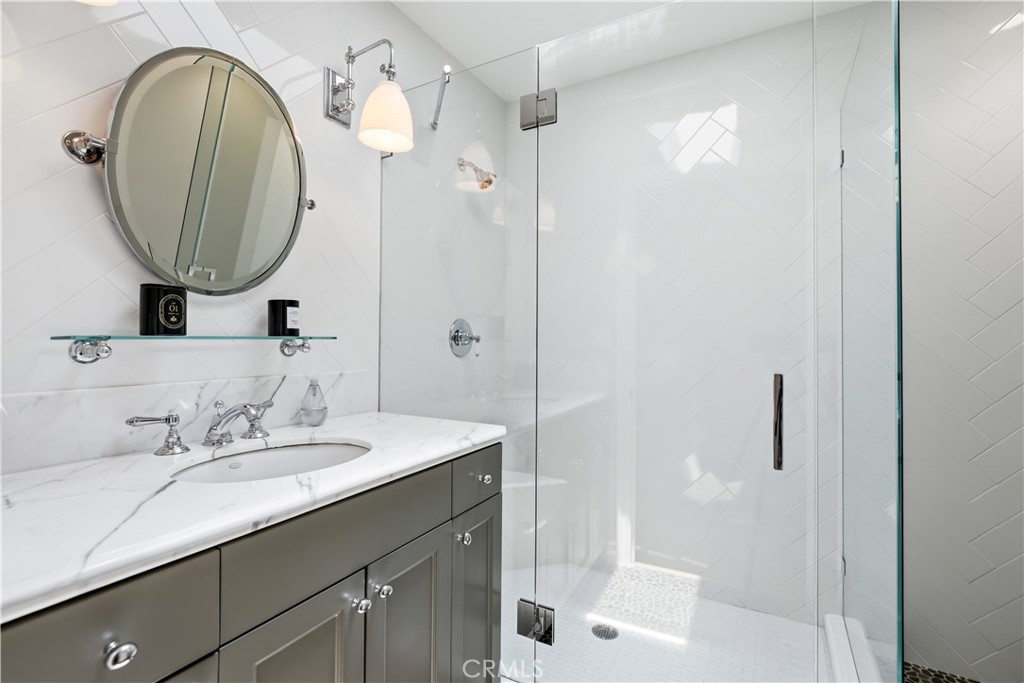 5460 Round Meadow Road Hidden Hills, CA 91302 - Photo 17 of 29 a bathroom with a sink a mirror a vanity and a shower