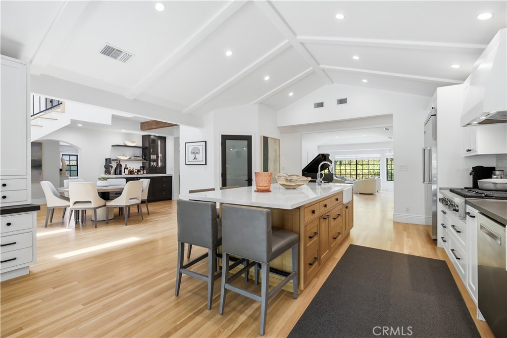 5460 Round Meadow Road Hidden Hills, CA 91302 - Photo 5 of 29 a large kitchen with stainless steel appliances a table chairs and a refrigerator