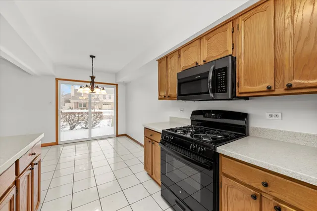 a kitchen with a stove a microwave and wooden cabinets
