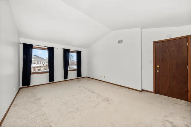 a view of an empty room with a window and fireplace