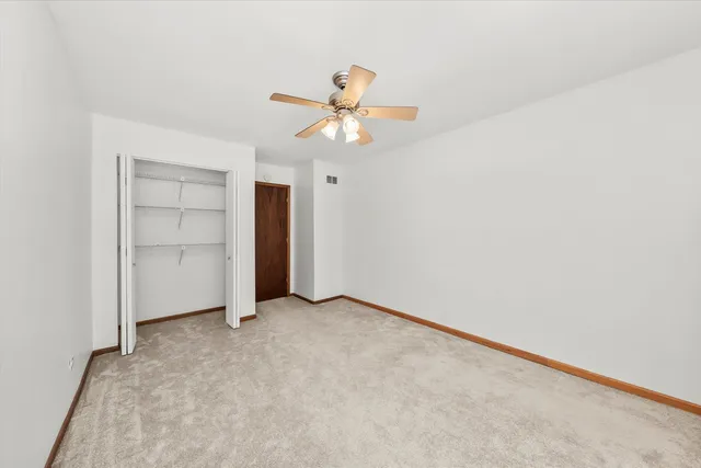 an empty room with a ceiling fan and a window
