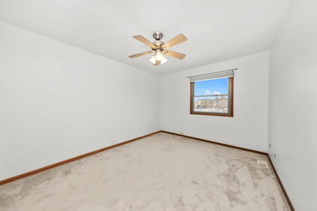 an empty room with a window and a ceiling fan