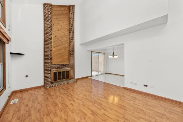 a view of an empty room with a fireplace and a window