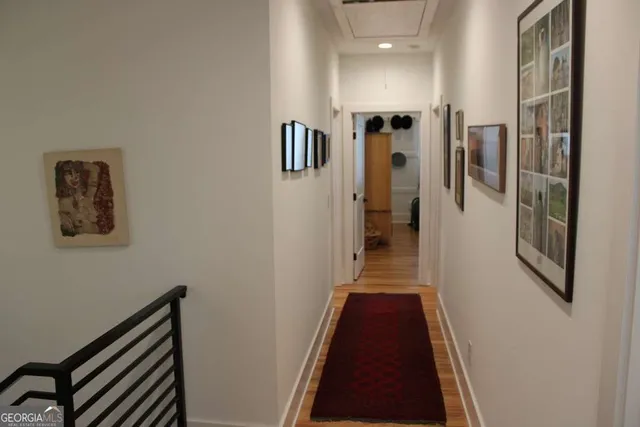 a view of a hallway with wooden floor and staircase