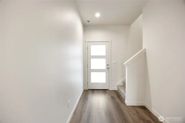 a view of a hallway with wooden floor