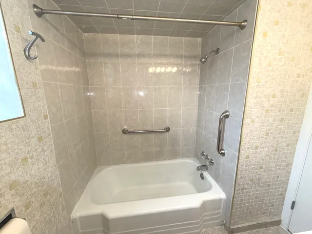 a bathroom with a shower and a bath tub