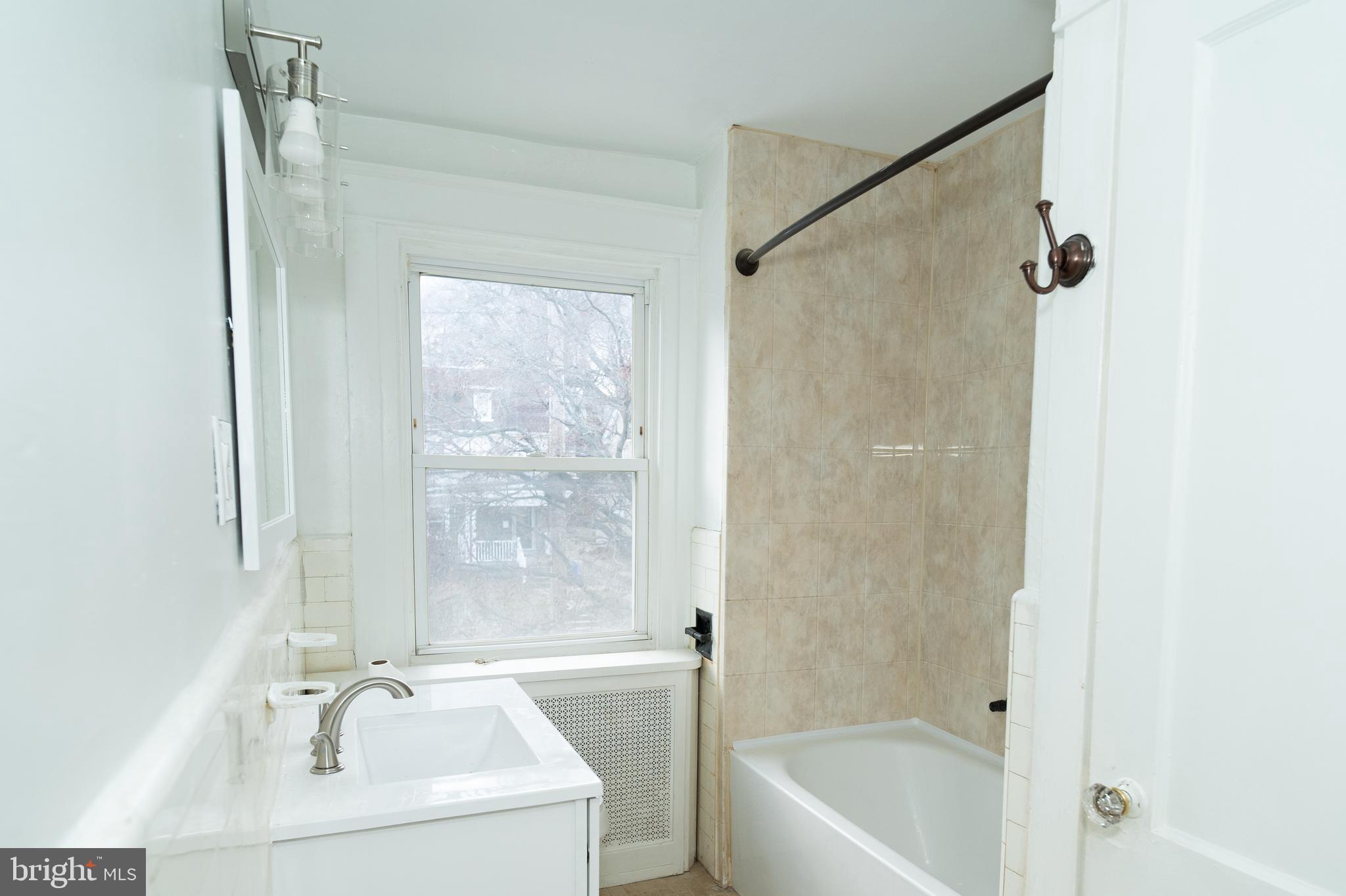 7209 Hazel Avenue Upper Darby, PA 19082 - Photo 26 of 35 a bath tub sitting next to a white sink and a shower
