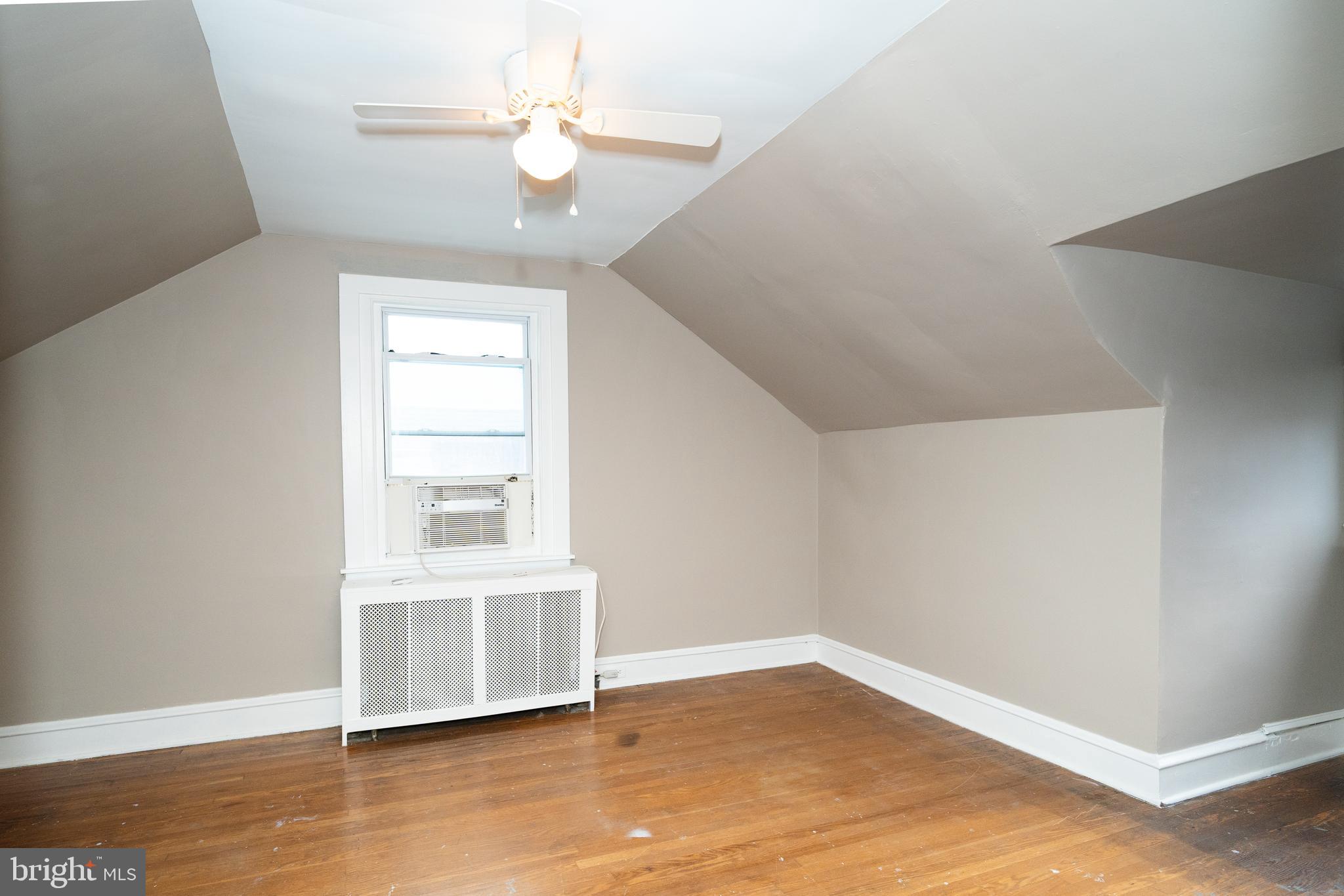 7209 Hazel Avenue Upper Darby, PA 19082 - Photo 28 of 35 an empty room with wooden floor chandelier fan and windows
