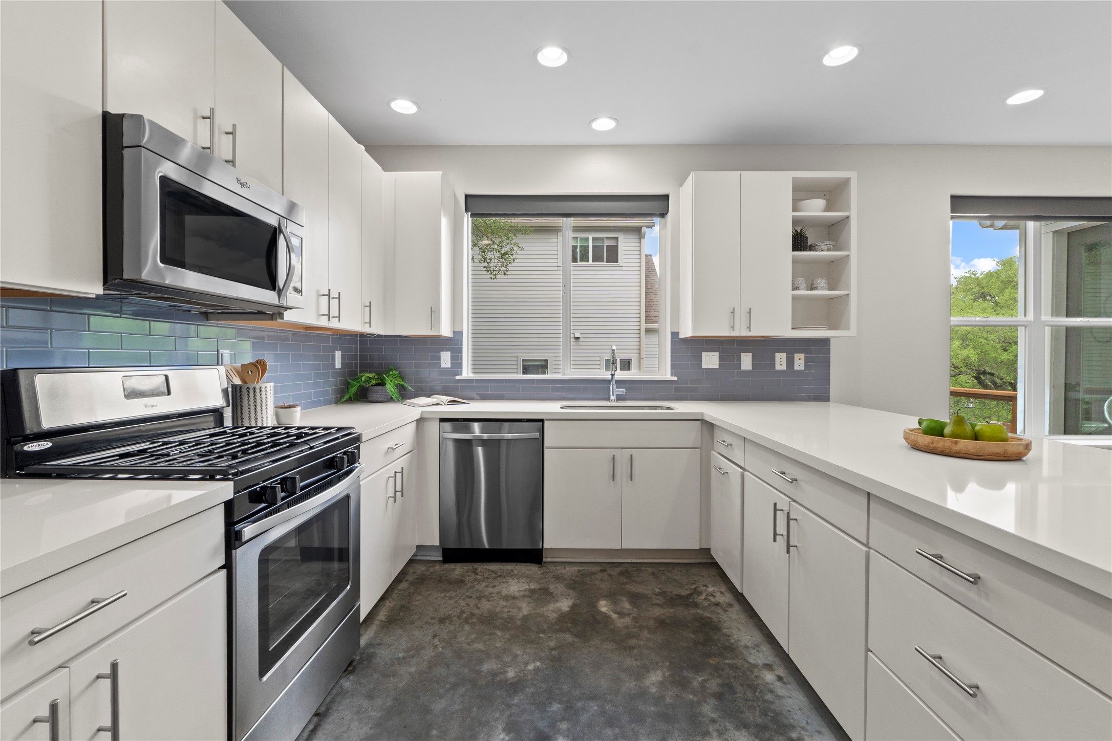 3001 Del Curto Road, Unit 35 Austin, TX 78704 - Photo 6 of 22 The kitchen features white cabinetry, white countertops, stainless steel appliances, a blue tile backsplash, and recessed lighting