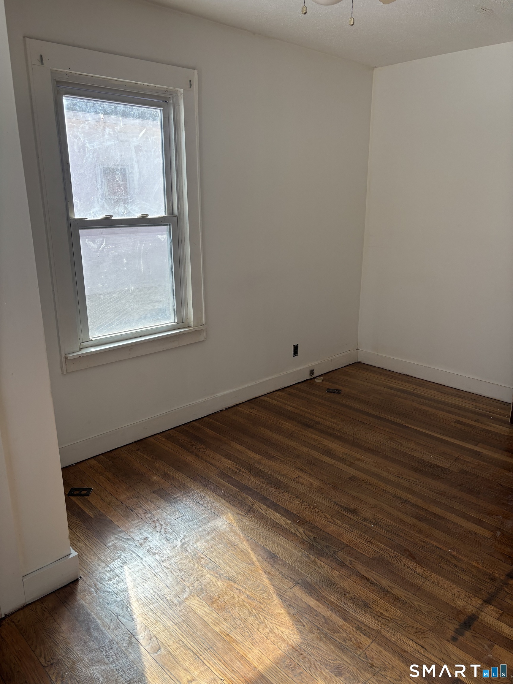 88 Walnut Street East Hartford, CT 06108 - Photo 2 of 8 an empty room with wooden floor and windows