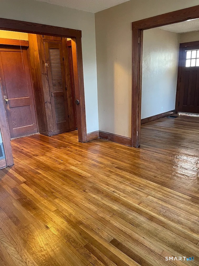 88 Walnut Street East Hartford, CT 06108 - Photo 5 of 8 a view of an empty room with wooden floor and a window