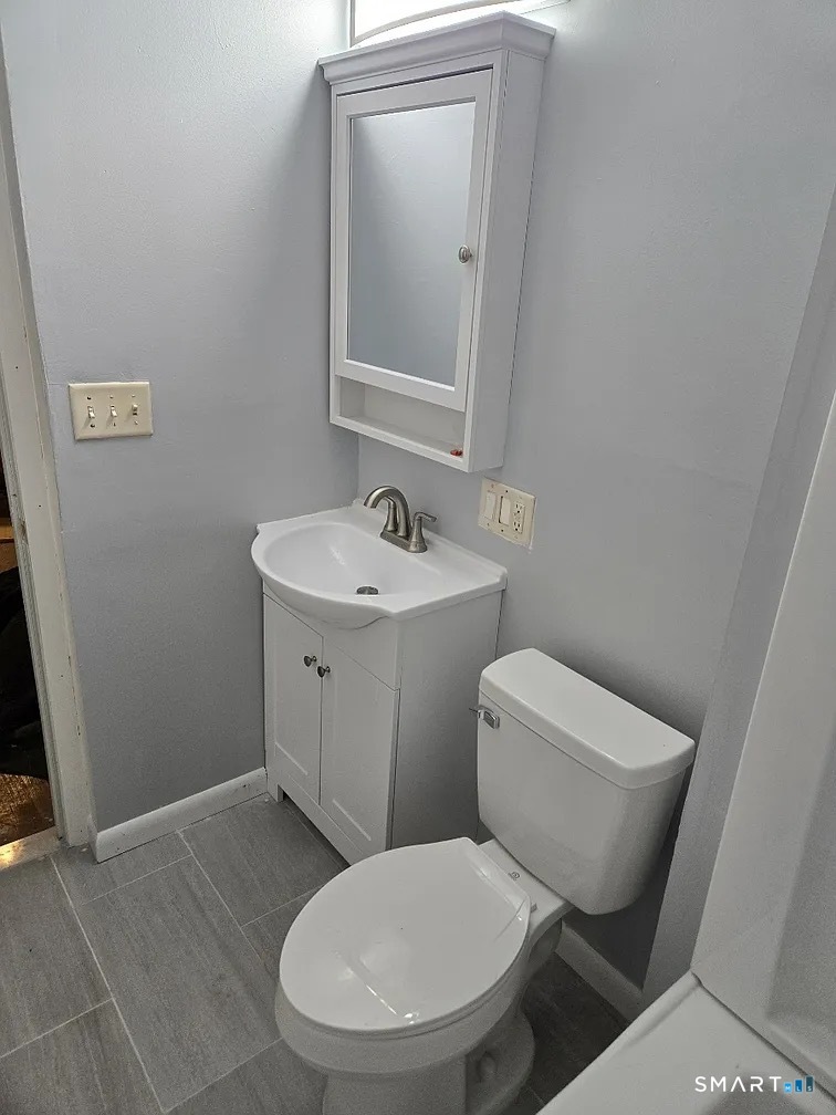 88 Walnut Street East Hartford, CT 06108 - Photo 7 of 8 a white toilet sitting next to a bathroom sink