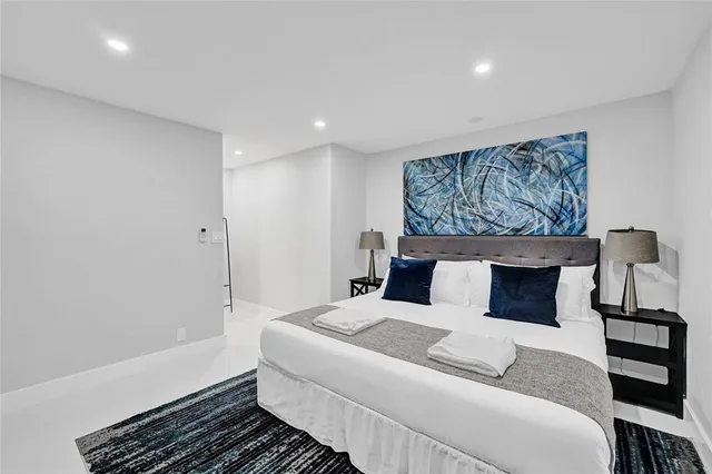 a bedroom with a large bed and a lamp