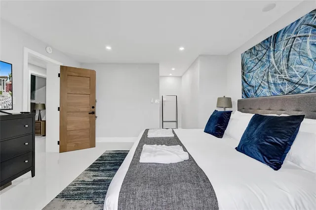 a large bedroom with a bed and wooden floor