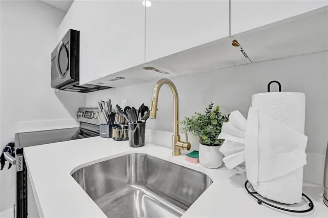 a kitchen with a faucet a potted plant and a sink