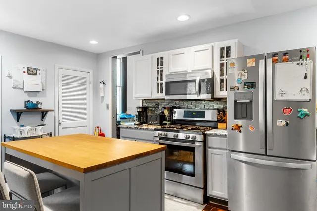 a kitchen with stainless steel appliances a stove a refrigerator and a refrigerator