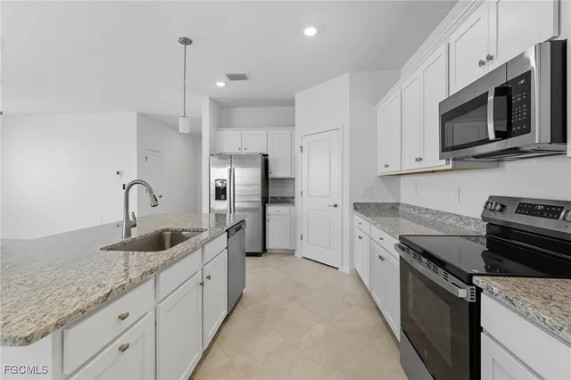 a kitchen with granite countertop a sink stainless steel appliances and cabinets