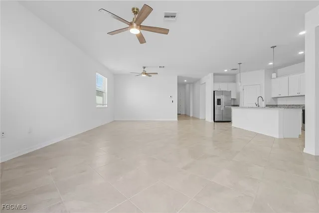 an empty room with a window and a ceiling fan