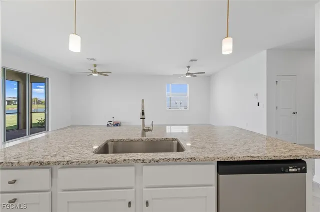 a kitchen with a sink a counter space and cabinets