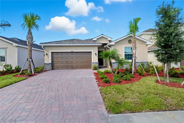 a front view of a house with a garden and yard